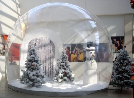 Display Snow Globe Snow globe scene with two pine trees, a snowman, and a snowy landscape indoors.