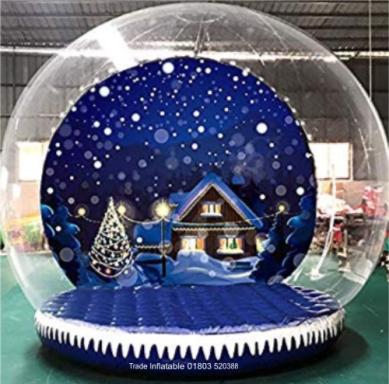 Air Filled Base A snow globe featuring a winter scene with a cottage and decorated Christmas tree.